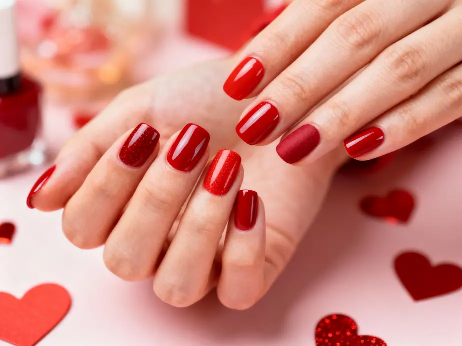 Stylish red nails perfect for Valentine's Day with various nail polish finishes