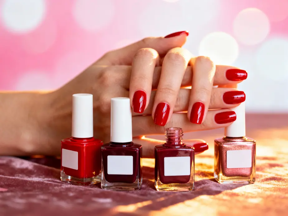 A collection of red nail polishes for Valentine's Day showcasing various shades from cherry red to deep burgundy.